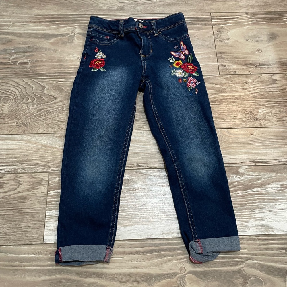 Dark wash denim jeans with floral detailing